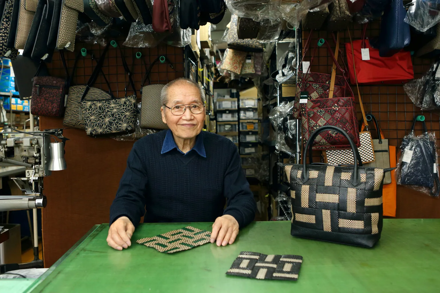 話を聞かせてくれた三紅の代表取締役・多田さん。工房には、デザインから縫製までを手掛けるバッグや革小物がずらりと並ぶ。
