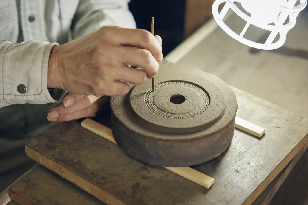 鉄瓶の蓋部分の模様付け作業。