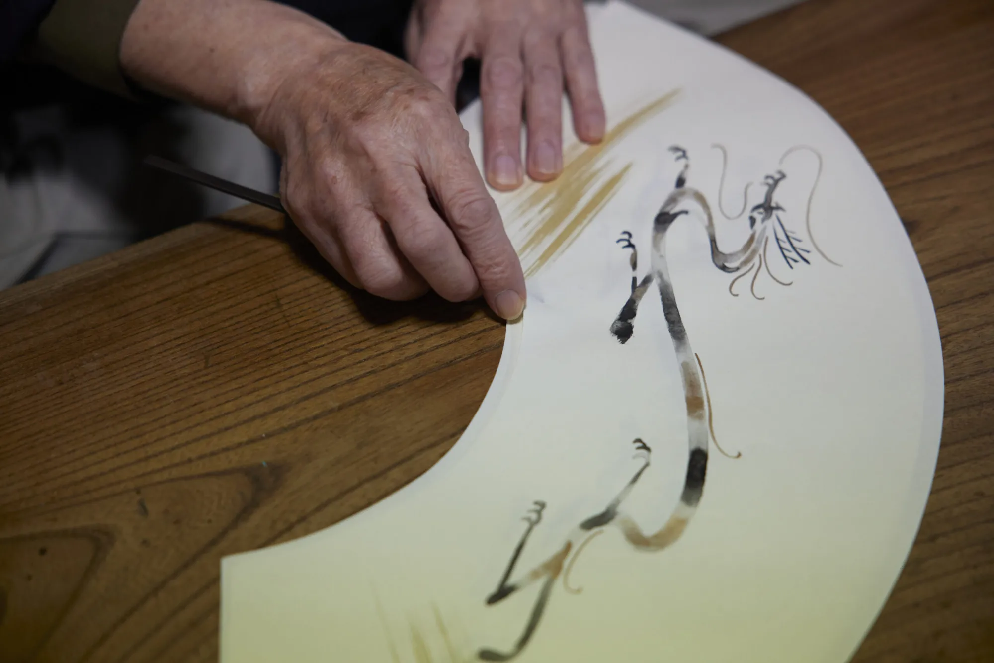 「平口開け」の作業。３枚重ね合わされた和紙は、下が透けて見えるほどに薄い。その紙の真ん中にヘラを通すのは、至難の技。