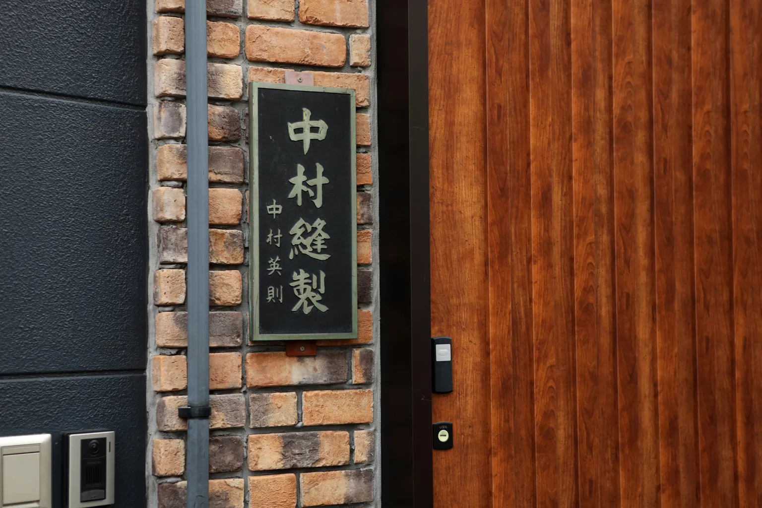 さりげなくも重厚な雰囲気を醸し出す「中村縫製」の看板。社名の脇には創業者である中村英則さんの名前が記されている。