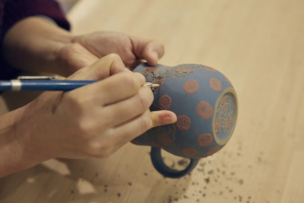 伝統的な「掻き落とし」の作業。下絵を描かずに、繊細な模様を手際よく描いていく。土が乾いてきてしまうため、時間との闘いだ。
