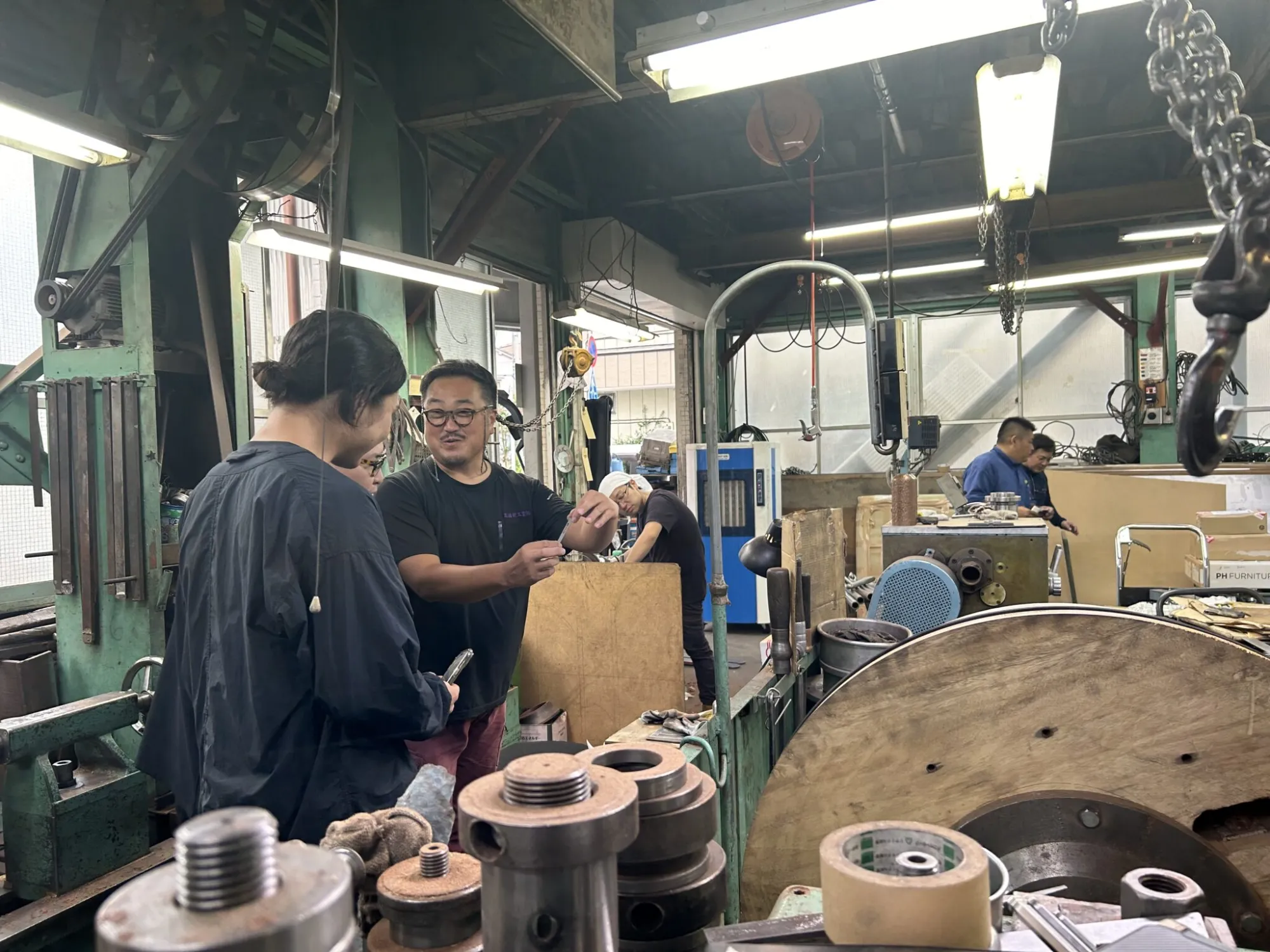 ヘラ絞りの技術について髙橋社長（左から3人目）がレクチャー。柳さんたちからの質問が途切れることなく続きます。