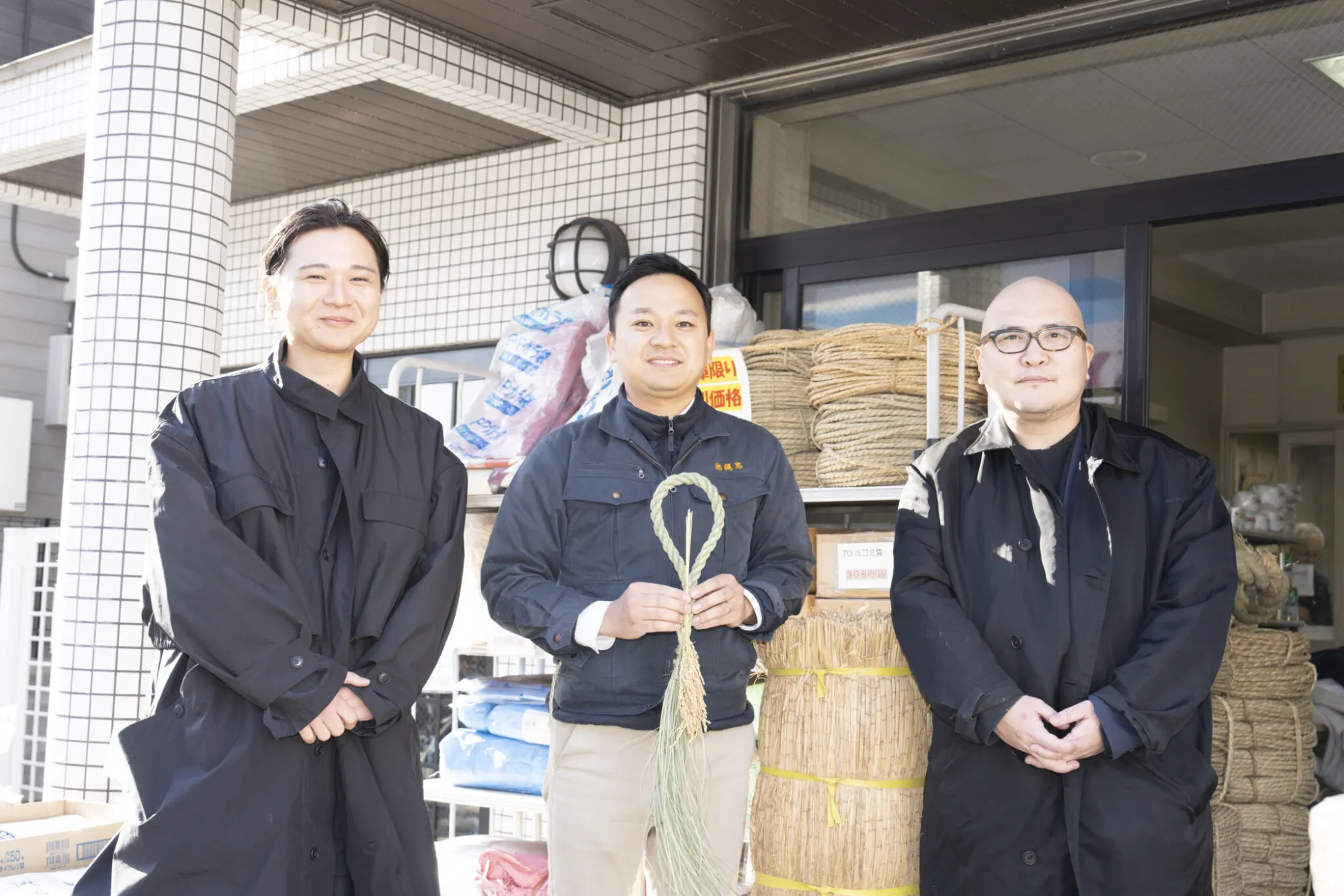 完成したしめ縄飾りと一緒に店頭で記念撮影。