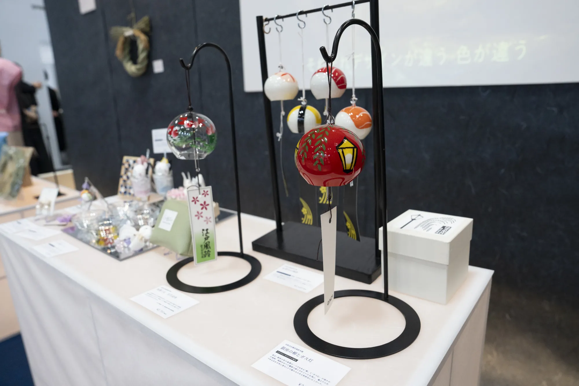 コラボ商品『銀座の柳とガス灯』（手前右）。背後に並ぶ寿司柄の風鈴は、女子美術大学と共同開発した「産学公プロジェクト」の商品。