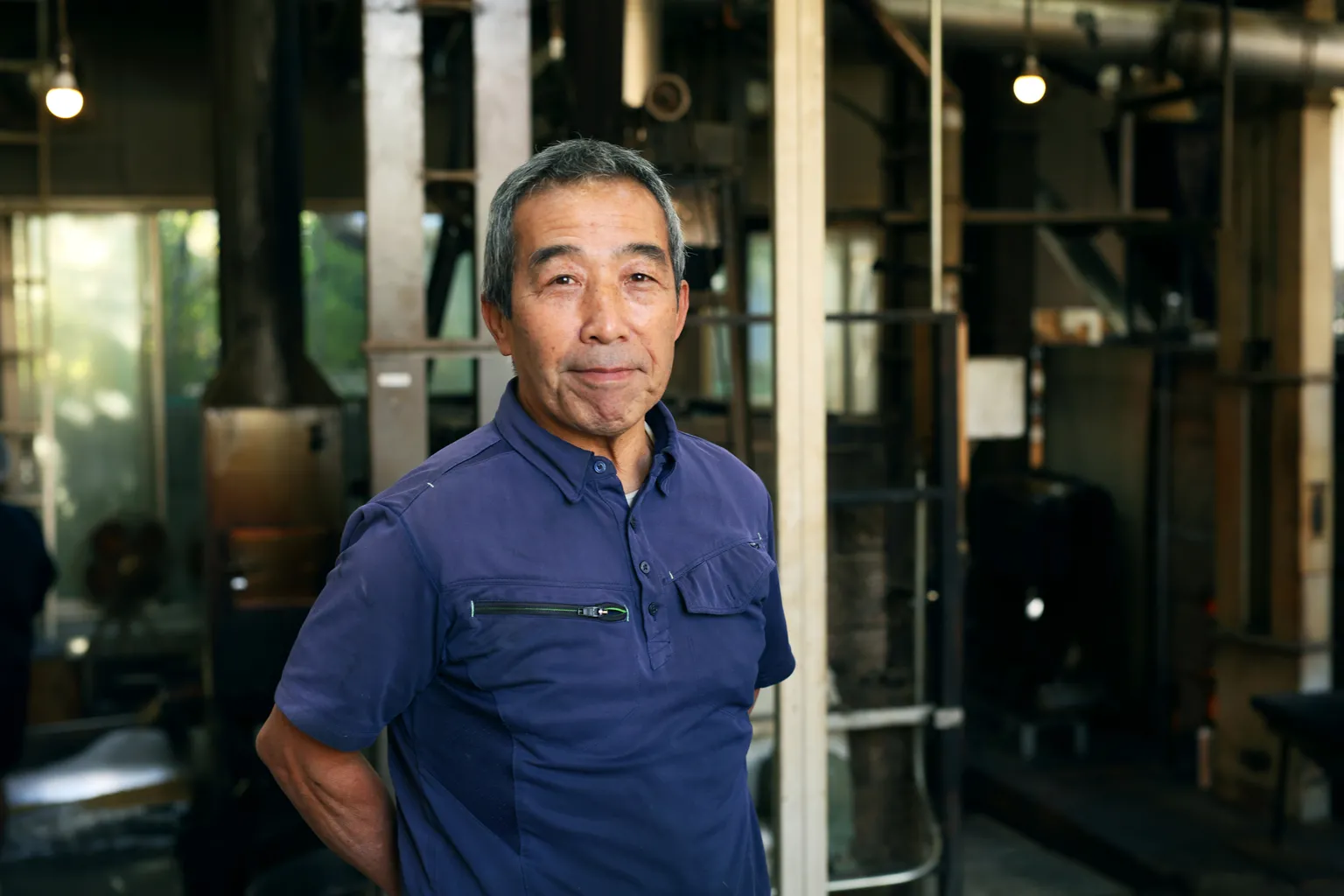 お話を聞かせてくれた小川産業の3代目社長である小川良雄さん。真っ直ぐな背筋と溌剌とした笑顔が印象的だ。「石窯を動かすと夏場の工場内は50度近くになるので体力が必要。健康でいられるのは、栄養のあるきな粉と麦茶をたくさん食べているからかもしれませんね」と微笑む。