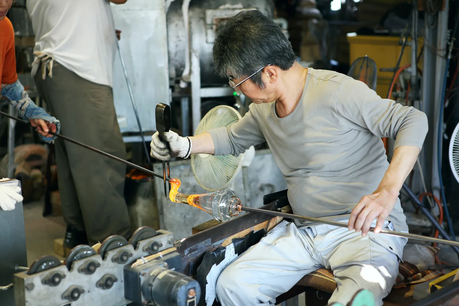 適切な量の柔らかいガラス生地を、適切なタイミングで受け渡し、あっという間に台の形に成形する。