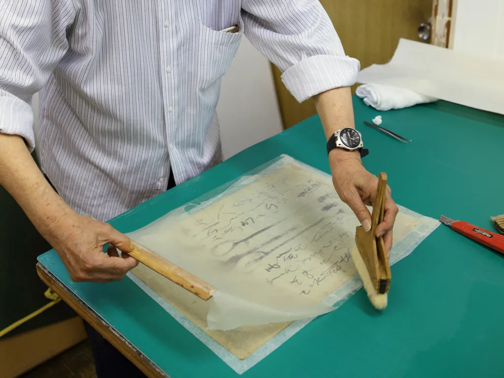 和紙に薄く溶いた糊を付け、補修した作品の裏側に重ね、柔らかいハケでシワを伸ばす。濡れた和紙があっという間にピンと張る様子は見事のひと言。