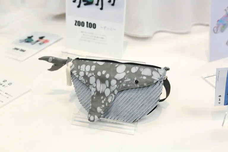 ゆったり泳ぐクジラをモチーフに、軽くて持ちやすい形に仕上げた子ども向けのショルダーバッグです。お出かけの時間にそっと寄り添うお供になるように、という願いが込められています。