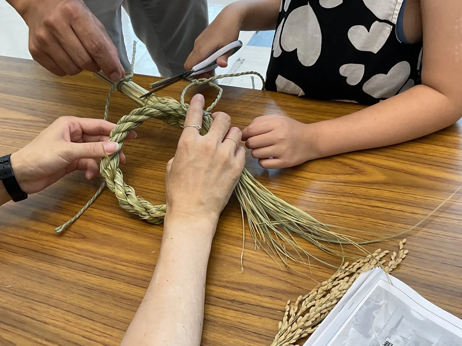 しめ縄飾りの形が見えてきました。途中で緩むことがあっても、3人で助け合いながら作業を進めます。